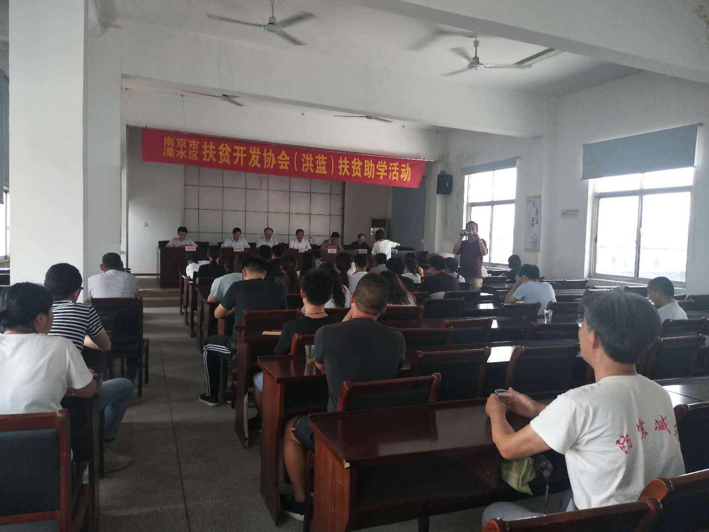 市、区老区扶贫“三会"陪同市驾培协会到洪蓝街道开展扶贫助学活动