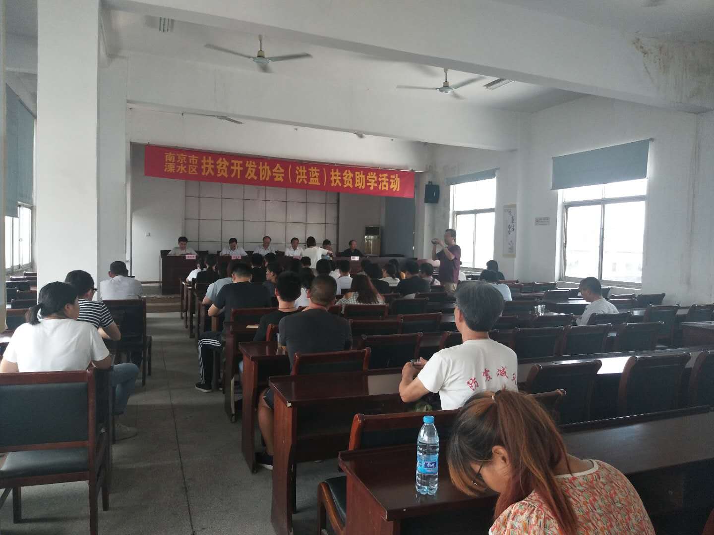 市、区老区扶贫“三会"陪同市驾培协会到洪蓝街道开展扶贫助学活动