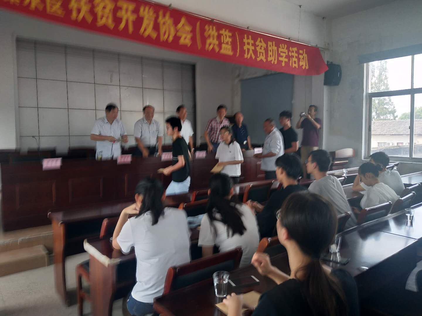 市、区老区扶贫“三会"陪同市驾培协会到洪蓝街道开展扶贫助学活动