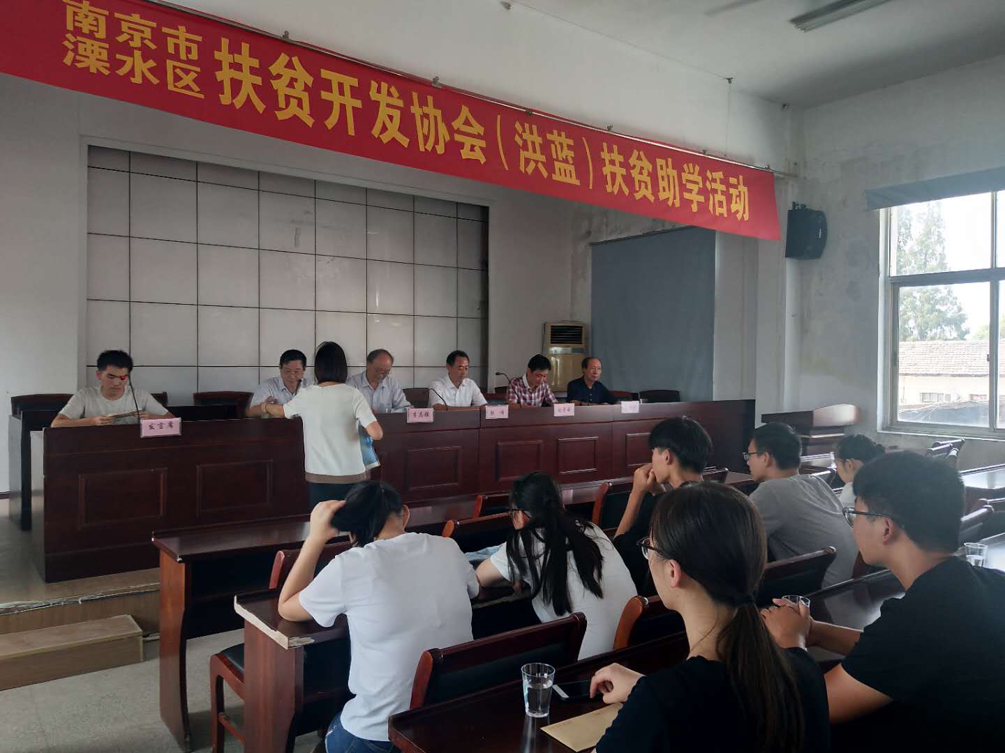 市、区老区扶贫“三会"陪同市驾培协会到洪蓝街道开展扶贫助学活动